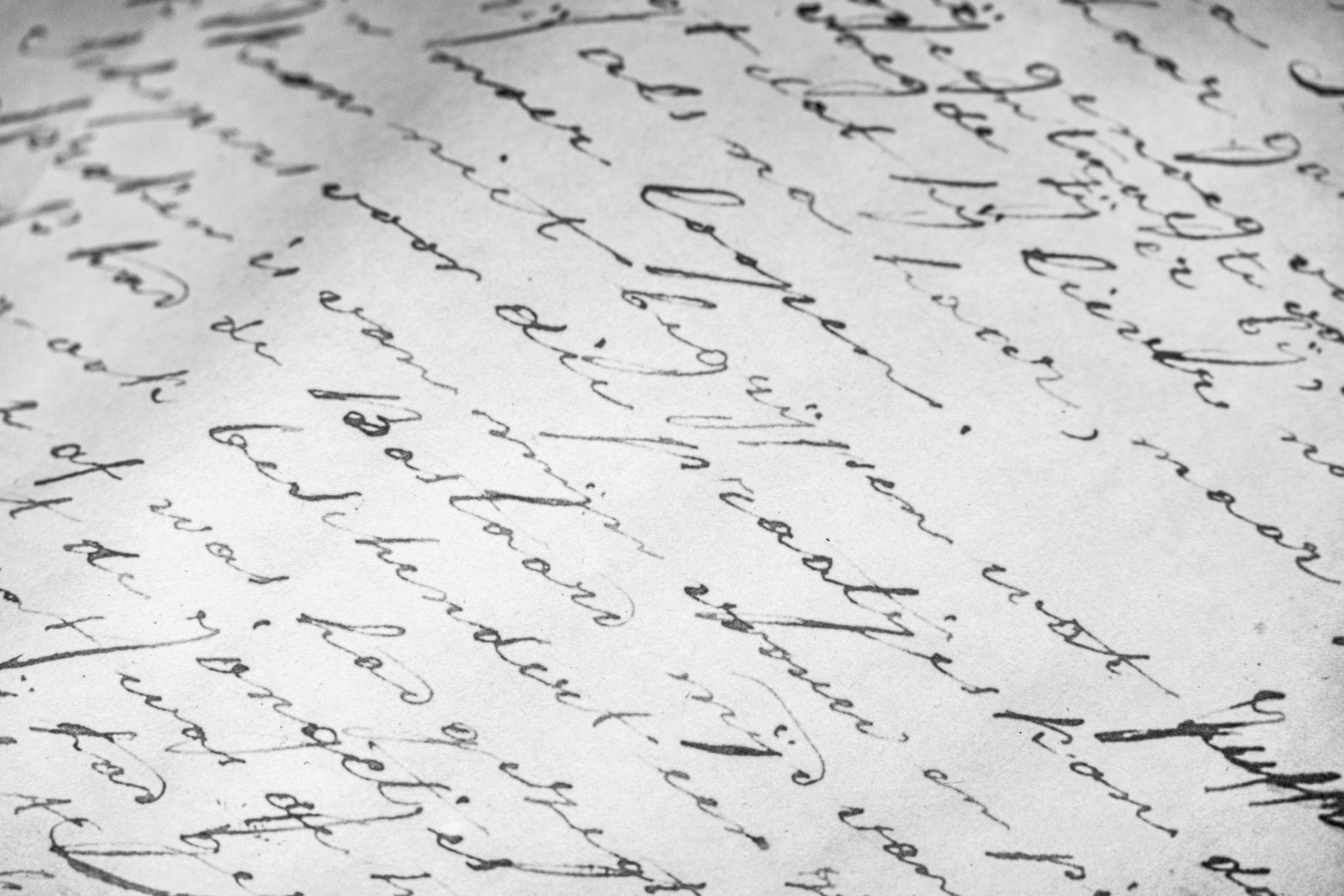 Detalle en blanco y negro de un texto manuscrito en letra cursiva sobre papel envejecido